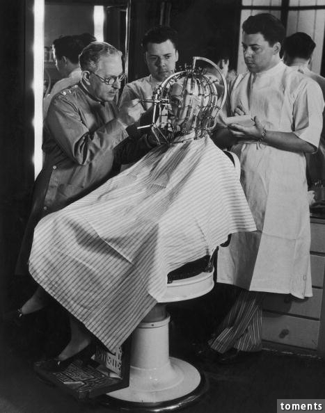 Max Factor takes precise measurements of a young woman's head and face with his "Beauty Calibrator" (1932). Beauty has never been so horrifying.